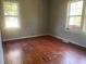 Simple bedroom with hardwood floors and two windows at 6658 Williams Rd, Seffner, FL 33584