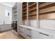Well-organized laundry room with built-in shelves, storage cabinets, countertops, and modern appliances at 1940 Hawaii Ne Ave, St Petersburg, FL 33703