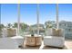 Sitting area includes white chairs with patterned pillows, an ocean view, and modern furnishings at 1940 Hawaii Ne Ave, St Petersburg, FL 33703