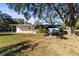 Mobile home exterior with a large backyard and shade tree at 26804 Chianina Dr, Wesley Chapel, FL 33544