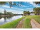 Walkway along waterfront with grassy areas and calm water views at 6321 Newtown Cir # 21B4, Tampa, FL 33615