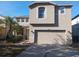Two-story house with a neutral color exterior, two-car garage, and landscaping at 10319 Boyette Creek Blvd, Riverview, FL 33569