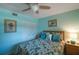 Bedroom with floral bedding, ceiling fan, and wood dresser at 11485 Oakhurst Rd # A203, Largo, FL 33774