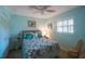 Bedroom with floral bedding, ceiling fan, and window shutters at 11485 Oakhurst Rd # A203, Largo, FL 33774