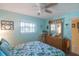 Light blue bedroom with floral bedding and ceiling fan at 11485 Oakhurst Rd # A203, Largo, FL 33774