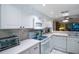 White kitchen cabinets, gas cooktop and view to living room at 11485 Oakhurst Rd # A203, Largo, FL 33774
