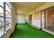 Bright screened porch featuring green flooring and access to outdoors at 4300 58Th N St # 1907, Kenneth City, FL 33709