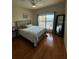 Main bedroom with wood floors and balcony access at 1216 S Missouri Ave # 317, Clearwater, FL 33756