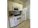 White kitchen cabinets, modern appliances and a breakfast bar at 1216 S Missouri Ave # 317, Clearwater, FL 33756