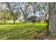 Large grassy backyard with view of screened lanai and exterior of the house at 106 Rosana Dr, Brandon, FL 33511