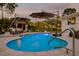 Relaxing kidney-shaped pool, surrounded by a patio and landscaping at 1615 Santa Barbara Dr, Dunedin, FL 34698