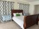 Comfortable bedroom with a sleigh bed, blue nightstands, and stylish patterned curtains at 1948 Jeffords St, Clearwater, FL 33764