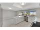 Modern kitchen with white cabinets, quartz countertops, and stainless steel appliances at 1011 Spindle Palm Way, Apollo Beach, FL 33572