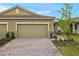 Tan two-car garage home with paved driveway and landscaped walkway at 20363 Symphony Pl, Venice, FL 34293