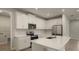 Modern kitchen with white cabinets, quartz countertops, and stainless steel appliances at 20363 Symphony Pl, Venice, FL 34293