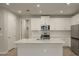 Modern kitchen with white cabinets, quartz countertops, and stainless steel appliances at 20363 Symphony Pl, Venice, FL 34293