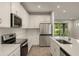 Modern kitchen with stainless steel appliances and white cabinetry at 20363 Symphony Pl, Venice, FL 34293