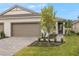 New construction home exterior with two-car garage and landscaped yard at 20375 Symphony Pl, Venice, FL 34293