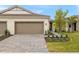 New construction home exterior, featuring a two-car garage and a manicured lawn at 20375 Symphony Pl, Venice, FL 34293