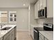 Modern kitchen with stainless steel appliances and white cabinets at 20375 Symphony Pl, Venice, FL 34293