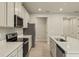 Modern kitchen with stainless steel appliances and light gray cabinets at 20375 Symphony Pl, Venice, FL 34293