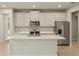 Modern kitchen with island, stainless steel appliances, and light cabinets at 20375 Symphony Pl, Venice, FL 34293