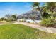 Landscaped backyard with a walkway, lush foliage and screened enclosure at 6613 Seabird Way, Apollo Beach, FL 33572