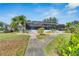 Landscaped backyard with a walkway leading to a screened pool area at 6613 Seabird Way, Apollo Beach, FL 33572