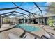 Relaxing kidney-shaped pool with screened enclosure and patio furniture at 6613 Seabird Way, Apollo Beach, FL 33572