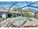 Large, kidney-shaped pool with screened enclosure, overlooking the water at 6613 Seabird Way, Apollo Beach, FL 33572
