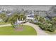 Aerial view of waterfront home with circular driveway, lush landscaping, and private dock at 411 Belle Isle Ave, Belleair Beach, FL 33786