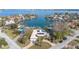 Aerial view of a waterfront house with a pool and solar panels at 411 Belle Isle Ave, Belleair Beach, FL 33786