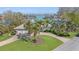 Aerial view of waterfront home with circular driveway and lush landscaping at 411 Belle Isle Ave, Belleair Beach, FL 33786