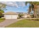 House exterior showcasing a two-car garage and well-manicured lawn at 411 Belle Isle Ave, Belleair Beach, FL 33786