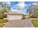 Exterior view of two-car garage and brick paver driveway at 411 Belle Isle Ave, Belleair Beach, FL 33786