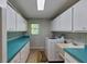 Bright laundry room with teal countertops and storage at 411 Belle Isle Ave, Belleair Beach, FL 33786