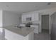 Modern kitchen with white cabinets, granite countertops and island at 17002 Oval Rum Dr, Wimauma, FL 33598