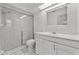 Clean bathroom featuring a walk-in shower with glass door, a toilet, and a vanity sink at 2233 Curlew Rd, Dunedin, FL 34698
