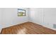 Empty bedroom with wood floors, closet, a window and white walls at 2233 Curlew Rd, Dunedin, FL 34698