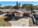 Aerial shot of home with front lawn, garage, brick facade and well-maintained surroundings at 2233 Curlew Rd, Dunedin, FL 34698