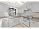 Well-lit kitchen features a stainless steel sink, white cabinets, and granite countertops at 2233 Curlew Rd, Dunedin, FL 34698