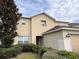 Two-story house with beige exterior, attached garage, and landscaping at 32111 Brookstone Dr, Wesley Chapel, FL 33545