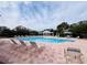 Community swimming pool with lounge chairs and cabana at 32111 Brookstone Dr, Wesley Chapel, FL 33545