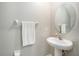 Small bathroom with pedestal sink, oval mirror, and white finishes at 3873 Gainer Spring Avenue, New Port Richey, FL 34653