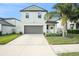 Two-story house with gray siding, two-car garage, and landscaped yard at 3873 Gainer Spring Avenue, New Port Richey, FL 34653