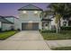 Two-story house with gray siding, two-car garage, and landscaped yard at 3873 Gainer Spring Avenue, New Port Richey, FL 34653