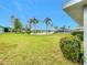 Spacious backyard with lake view and lush tropical landscaping at 2460 Terry Ln, Sarasota, FL 34231