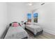Charming bedroom with two twin beds, light gray bedding, and hardwood floors at 3025 Oakmont Dr, Clearwater, FL 33761