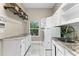 Bright laundry room with white cabinets, granite countertops, and a window at 3025 Oakmont Dr, Clearwater, FL 33761
