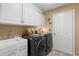 Efficient laundry room with washer, dryer, sink, and ample white cabinet storage at 1160 Darlington Oak Ne Dr, St Petersburg, FL 33703